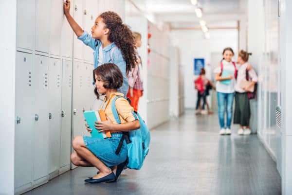 Girls Opening Lockers In School Corridor