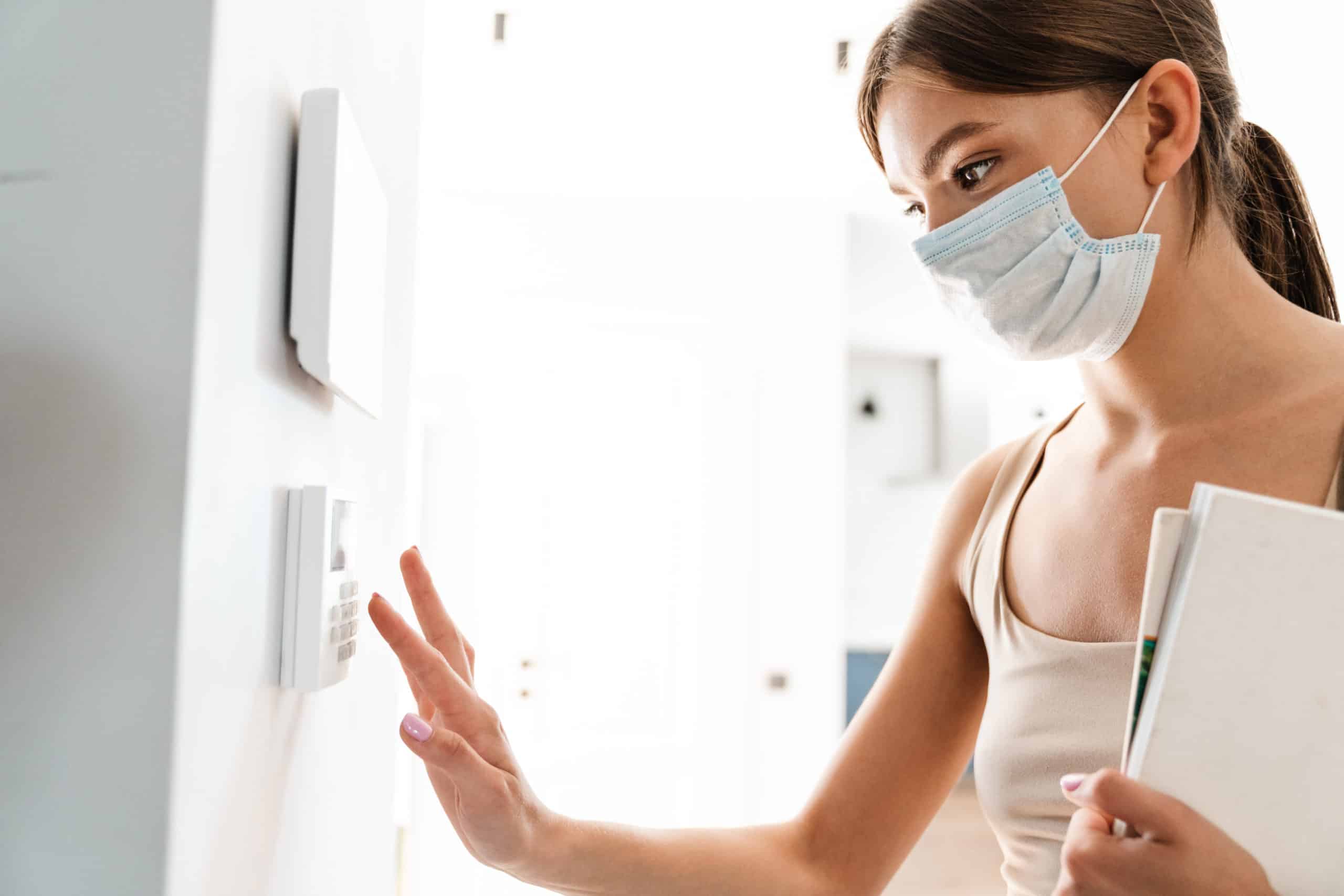 Young Woman In Medical Mask Entering Code On Keypad